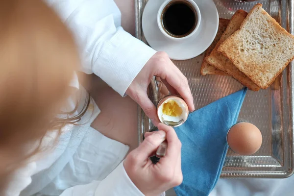 Breakfast in bed in hotel. Redhead gird after taking shower has a breakfast in bed in hotel room.