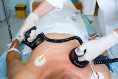 eller bir defibrilatör elektrodlar, holding Doktor defibrilasyon veya electropulse tedavi gerçekleştirme