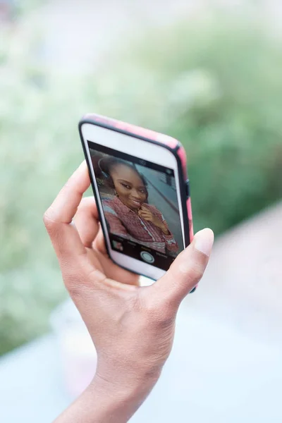 黒アフロの少女の手のスマート フォンを押しながら Selfie を作る — ストック写真