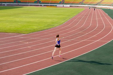 Spor. Pembe ayakkabı koşu parkuru stadyum üzerinde çalıştırmak atletik genç kadın. Kavram çalıştırın. Stadyum üzerinde rekabet çalıştırmak.