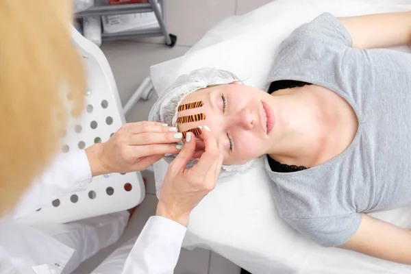 Cosmetólogo Haciendo Procedimiento Grabación Facial Usando Cintas Color Tigre Salón — Foto de Stock