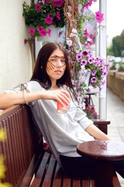 Kaplan genç çekici esmer kadın güzellik salonu sokak ve içme kahve oturan yüz yordamda kayıt sonra bantları renkli. Kavram güzellik.