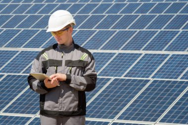 Güneş panelleri mühendis veya tablet vasıl seyir ve güneş güneş panelleri field yakınındaki işlemiyle kontrol işçi. Sıcak güneşli yaz hava. Alternatif enerji. Yenilenebilir ve temiz enerji, teknoloji kavramı. Çalışan insanlar.