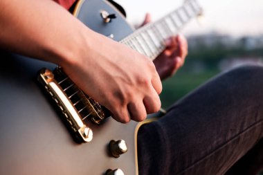 Açık havada elektro gitar çalmak, akşam gitarist elinde