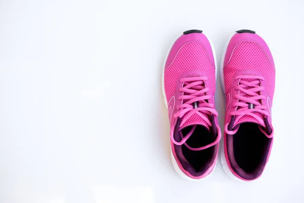 Concept run. Pink running shoes for women on a white background. Top view