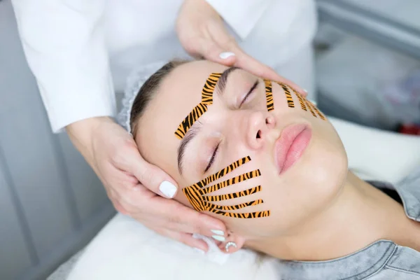 Cosmetólogo Haciendo Procedimiento Grabación Facial Usando Cintas Color Tigre Salón — Foto de Stock