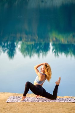 Yoga ya da pilates açık havada güzel neşeli mutlu kızıl saçlı kıvırcık kadının. Kavram aşk yoga.
