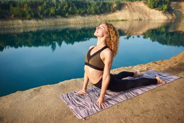 Meditasyon ve yoga ya da pilates açık havada sabah zevk kapalı gözler ile genç güzel kızıl saçlı kıvırcık kadın portresi. Kavram aşk yoga. Kavram aşk sabah. Meditasyon