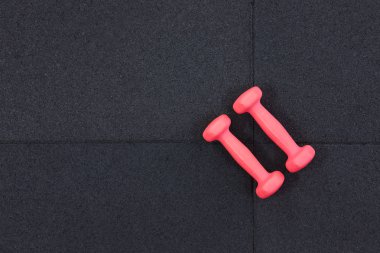 Siyah arka planda, düz görünüm pembe dumbeells çifti