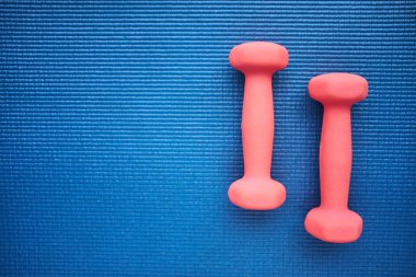 Mavi arka plan, üstten görünüm üzerinde pembe dumbeells çifti