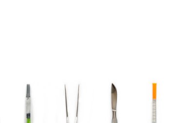Küme cosmetical cerrahi ekipman, düz beyaz arka plan üzerinde yatıyordu