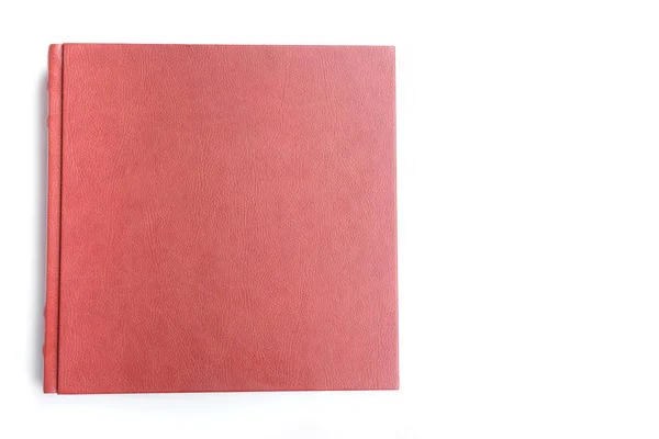 Red leather covered wedding album lie on white background. Top view. Copy space.