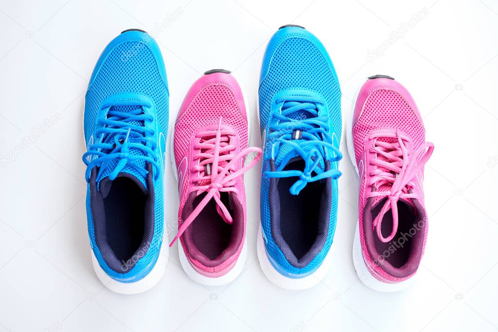 Pair of blue running sneakers for men and pair of pink one for women on white background. Concept love run. Run together. Family run. Top view.