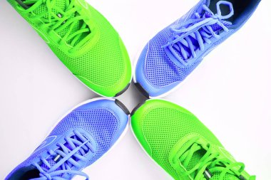 Bir çift spor ayakkabı erkek ve kadınlar için hafif yeşil bir çifti için çalışan beyaz zemin üzerine mavi. Kavram aşk çalıştırın. Birlikte çalıştırın. Aile. Üstten görünüm.