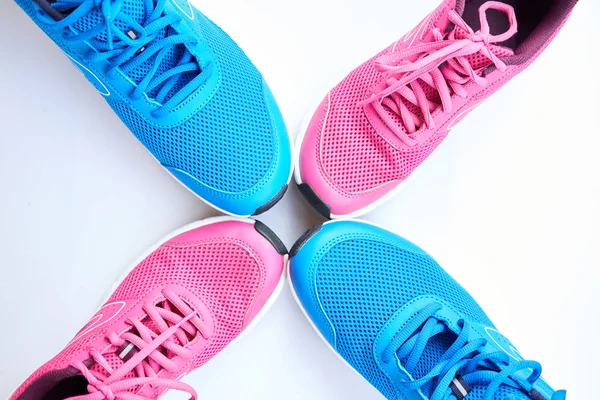 Pair of blue running sneakers for men and pair of pink one for women on white background. Concept love run. Run together. Family run. Top view.