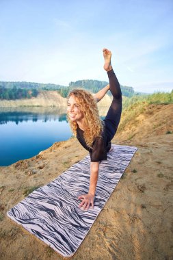 Çekici genç neşeli kadın pratik yoga ve yoga uzanan açık havada poz. Kavram aşk yoga. Kavram aşk sabah. Fitness ve sağlıklı yaşam tarzı. 