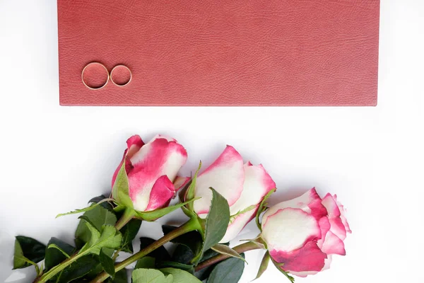 Livro de casamento coberto de couro vermelho ou álbum com duas alianças de casamento — Fotografia de Stock
