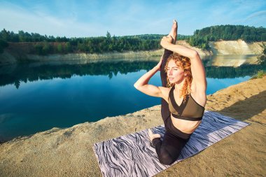 Kıvırcık çekici Kızıl saçlı kadın veya modeli strething ve pratik yoga açık havada. Kavram aşk yoga. Kavram aşk sabah. 