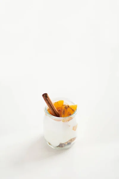 Банка греческого йогурта с мюсли, корицей и консервированными абрикосами — стоковое фото
