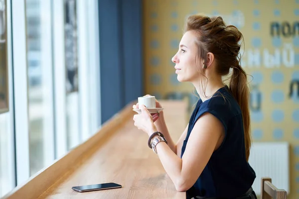 Kızıl saçlı beyaz kız karanlık mavi bluz kafede kahve içme bir — Stok fotoğraf