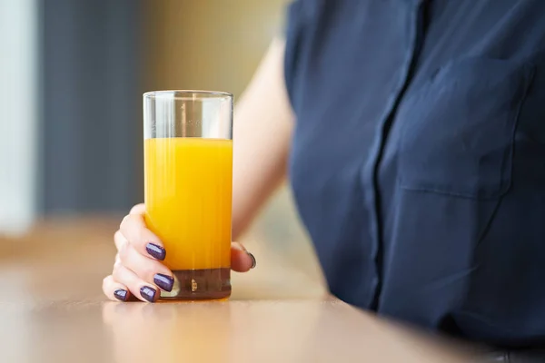 Τα χέρια της γυναίκας που κρατά ποτήρι χυμό πορτοκαλιού — Φωτογραφία Αρχείου