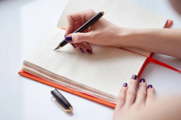 Notas de escritura de la mano de la mujer en el diario — Foto de Stock