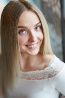 Genç sarışın gülümseyen kız ayakta portresi