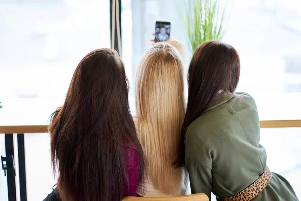 Vriendinnen hebben plezier in het café en het maken van de selfie — Stockfoto