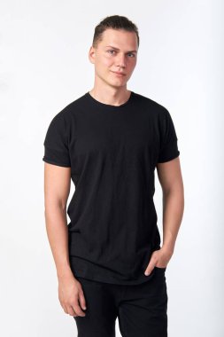 Kısa kollu siyah pamuk giyen yakışıklı genç gülümseyen adam 