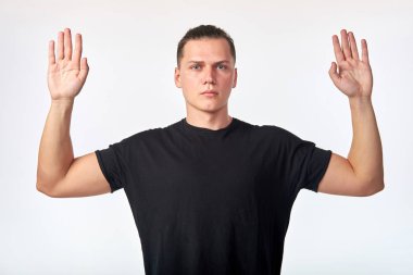 Pes ediyorum! Çekici genç adam beyaz backgrou üzerinde eller yükseltir