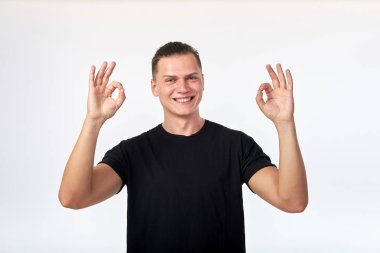 Siyah gömlek giyinmiş çekici cherrful genç adam ok gösteren 