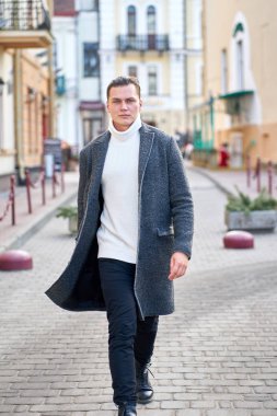 Gri bir ceket, beyaz kazak giyen genç çekici hipster adam 