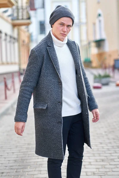 Молодой привлекательный хипстер в сером пальто, белый свитер — стоковое фото