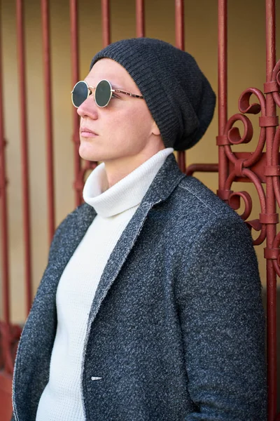 Jovem bonito hipster moderno homem em óculos de sol vestindo um cinza c — Fotografia de Stock