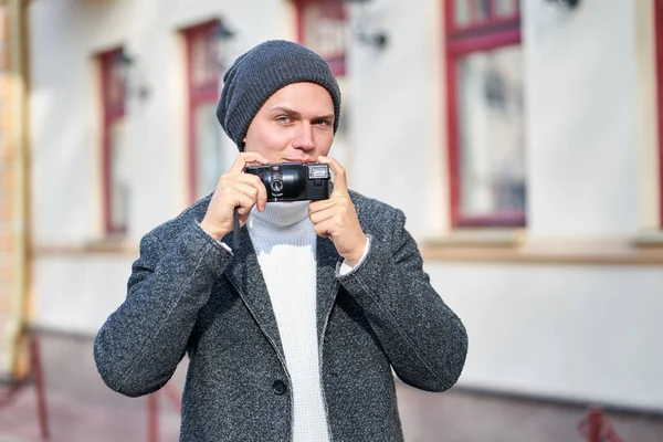 Bonito sorriso hipster na moda homem vestindo um casaco cinza, branco s — Fotografia de Stock