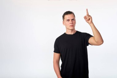 Genç, çekici, ciddi bir adam işaret parmağını kaldırıyor. 