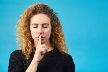 Kapalı gözlü güzel genç kızıl saçlı kıvırcık kadın finge tutar