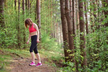 Atletik genç beyaz kadın pembe spor kıyafeti çalıştırdıktan sonra