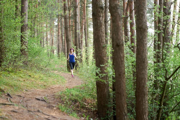 Atlética joven en zapatillas de deporte de color rosa corren en el bosque de primavera — Foto de Stock