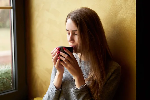 Jong mooi meisje met lang haar drinken koffie of thee in de — Stockfoto