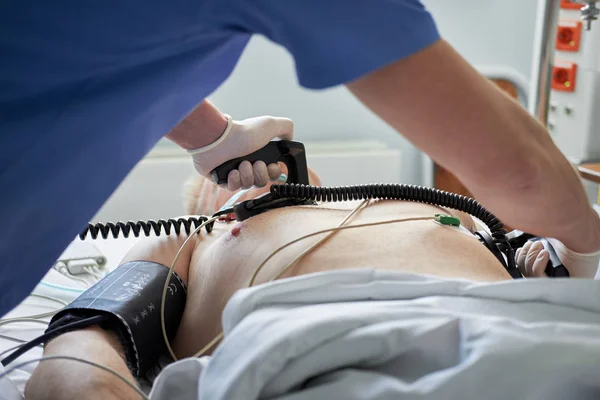 Läkare intensivist utför defibrillering till kritisk patient — Stockfoto