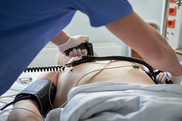 Doctor intensivist performs defibrillation to critical patient