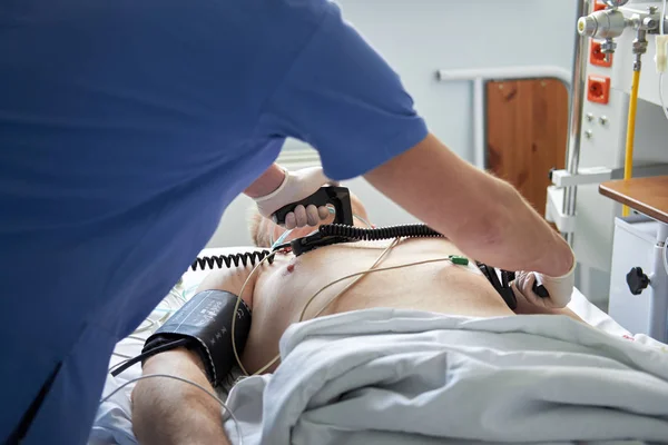 Medico intensivista esegue la defibrillazione al paziente critico — Foto Stock
