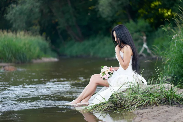 Beyaz gelinlik genç güzel esmer kadın th oturan — Stok fotoğraf