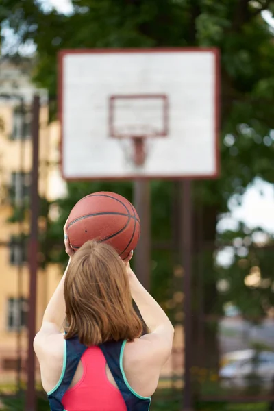빨간 머리 마른 소녀 던지는 공 에 농구 후프 야외 — 스톡 사진