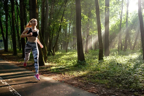 Mladá fitness sportovní žena, která ráno běží na lesní cestě — Stock fotografie