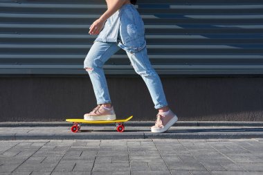 Mavi denim tulum ve trendy pembe Sneakers sürüyordum giyen kız