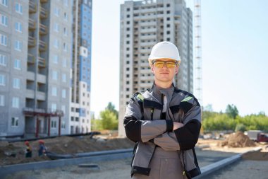 Beyaz koruyucu giyen genç yakışıklı sert işçi portresi 