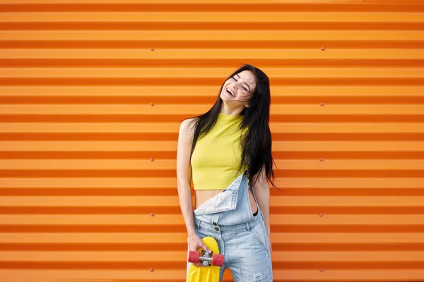 Divertida chica morena alegre con el pelo largo usando top amarillo a — Foto de Stock