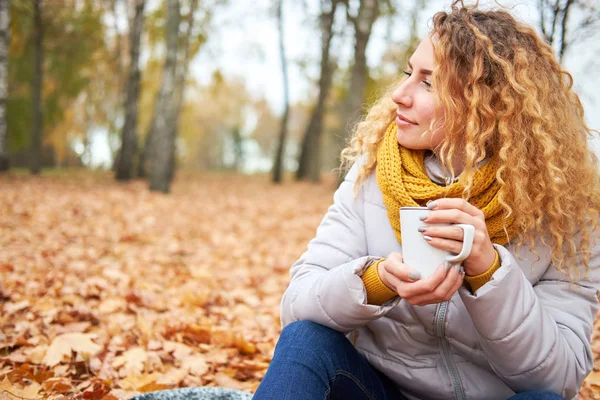 Rothaarige lockige fröhliche süße Mädchen Sitzen im Herbst Park, und halten — Stockfoto